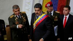 Venezuela's President Nicolas Maduro, center, stands with his Defense Minister Vladimir Padrino Lopez before giving his annual address to the nation to members of the Constitutional Assembly inside the National Assembly in Caracas, Venezuela, Jan. 14, 2019.
