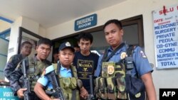 Armed Philippines policemen escort Indonesian national Muhamad Sofyan in Jolo, Provinsi Sulu, in 2016