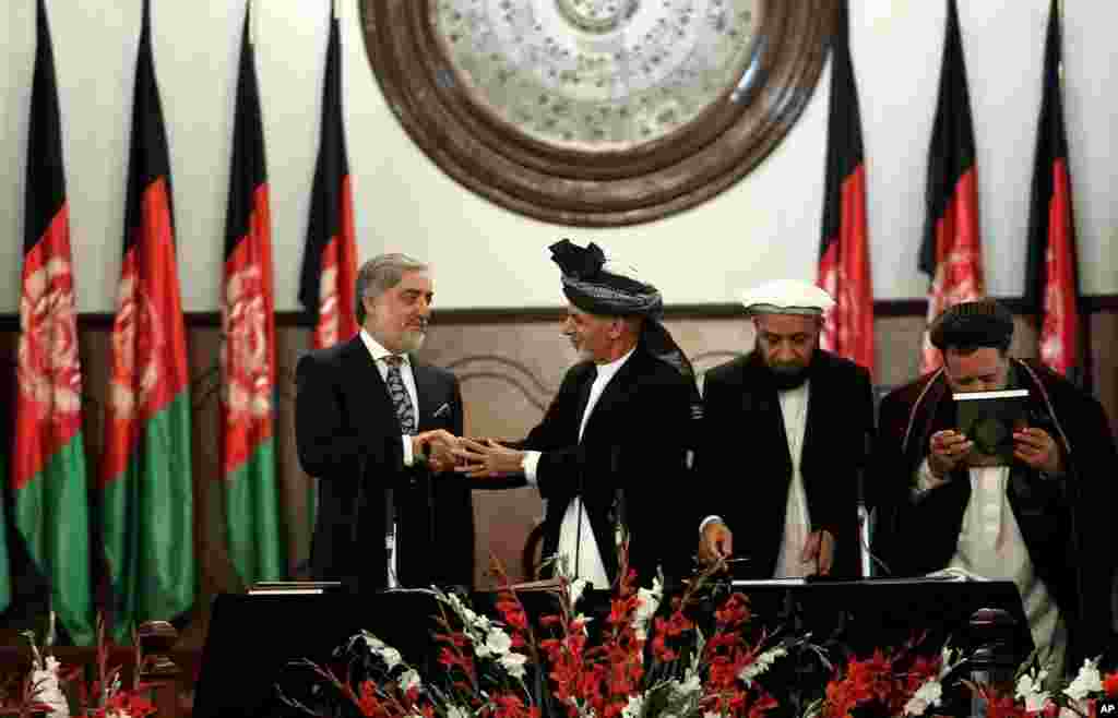 Afghan President Ashraf Ghani (second left) shakes hands with chief executive Abdullah Abdullah (left) during his inauguration ceremony at the presidential palace in Kabul, Afghanistan, Sept. 29, 2014. 