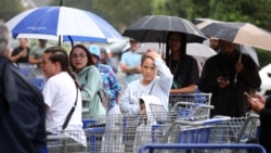 Warga setempat antre di tengah hujan sebelum gudang tempat belanja dibuka menjelang Badai Milton yang diperkirakan akan menerjang Kissimmee, Florida pada pertengahan minggu ini, 7 Oktober 2024. (Gregg Newton / AFP)