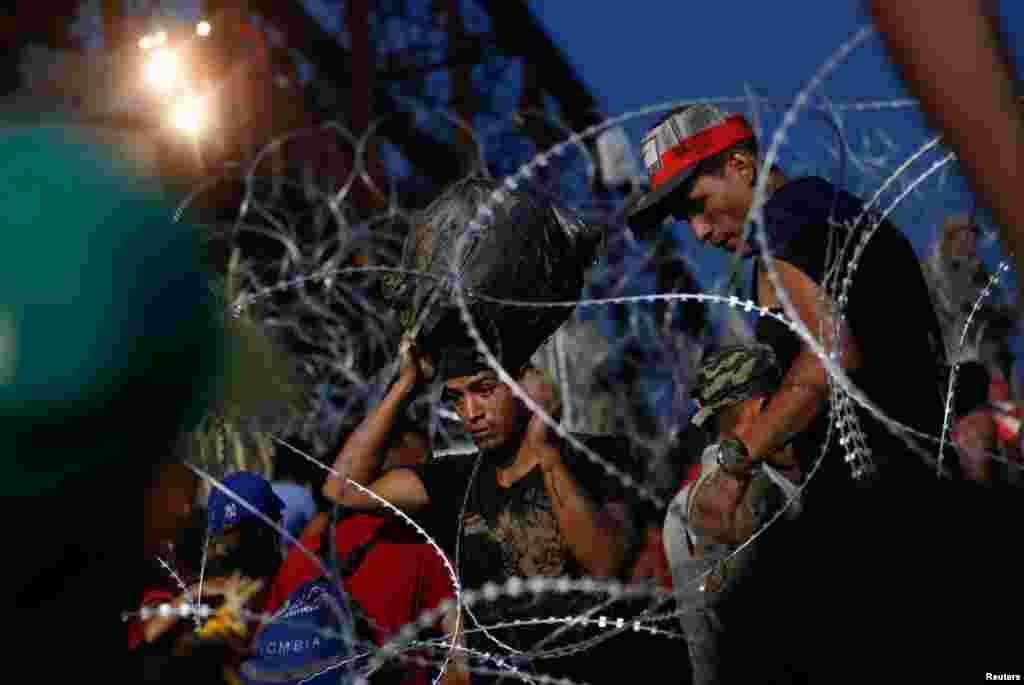 Asylum seekers wait on the banks of the Rio Bravo river after crossing during their journey through Mexico to Eagle Pass, Texas, in Piedras Negras, Mexico, Sept. 26, 2023.