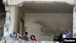 ARCHIVO - Niños palestinos en una casa destruida por un ataque israelí, en medio del conflicto en curso entre Israel y el grupo islamista palestino Hamas, en Rafah, sur de la Franja de Gaza, el 22 de mayo de 2024.