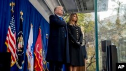 Presiden Donald Trump dan ibu negara Melania Trump berdiri di atas panggung saat upacara peletakan karangan bunga saat berlangsungnya peringatan Hari Veteran di Madison Square Park, New York, Senin, 11 November, 2019.