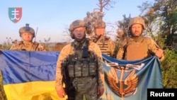 Ukrajinski vojnici stoje sa istaknutim zastavama Ukrajine u Urožajnu, u regionu Donjecka, 16. augusta 2023.