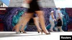 People walk past graffiti that aims to raise awareness of breast cancer ahead of Breast Cancer Awareness Month, Valletta, Malta, October 2013.