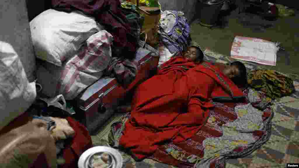 Boys sleep on the floor of a wedding hall after leaving their house to take shelter from the impact of the approaching Cyclone Phailin, in the eastern Indian state of Odisha.