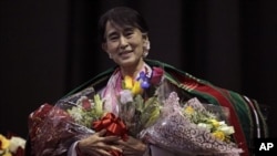 Aung San Suu Kyi tersenyum seusai menerima karangan bunga dan selendang tradisional Chin sebelum berpidato di Fort Wayne, Indiana, salah satu wilayah dengan komunitas Burma tebesar di AS (25/9). 