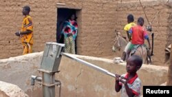 A child pumps water in the northern town of Kouroume, Mali, May 13, 2015.