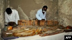 Des archéologues égyptiens examinent un sarcophage en bois découvert dans une tombe de l'ère pharaonique à Draa Abul Naga, près de Louxor, Egypte, le 18 avril 2017.