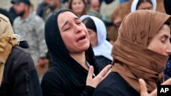 FILE - In this March 15, 2019, picture, Iraqi Yazidi women mourn during the exhumation of a mass grave in Iraq's northwestern region of Sinjar. 