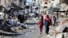 Palestinos caminan junto a las ruinas de casas destruidas durante la ofensiva militar de Israel, en medio del conflicto en curso entre Israel y Hamás, en la ciudad de Gaza, el 20 de marzo de 2024. La ONU ha condenado los ataques "cada día, esta guerra cobra más víctimas civiles".