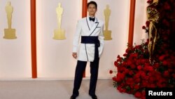 Harry Shum Jr. poses on the champagne-colored red carpet during the Oscars arrivals at the 95th Academy Awards in Hollywood, Los Angeles, California, March 12, 2023.