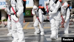 South Korean soldiers wearing protective gear sanitize a street in front of the city hall after the rapid rise in confirmed cases of the novel coronavirus disease of (COVID-19) in Daegu, southeast of the capital Seoul, South Korea, March 2, 2020. 