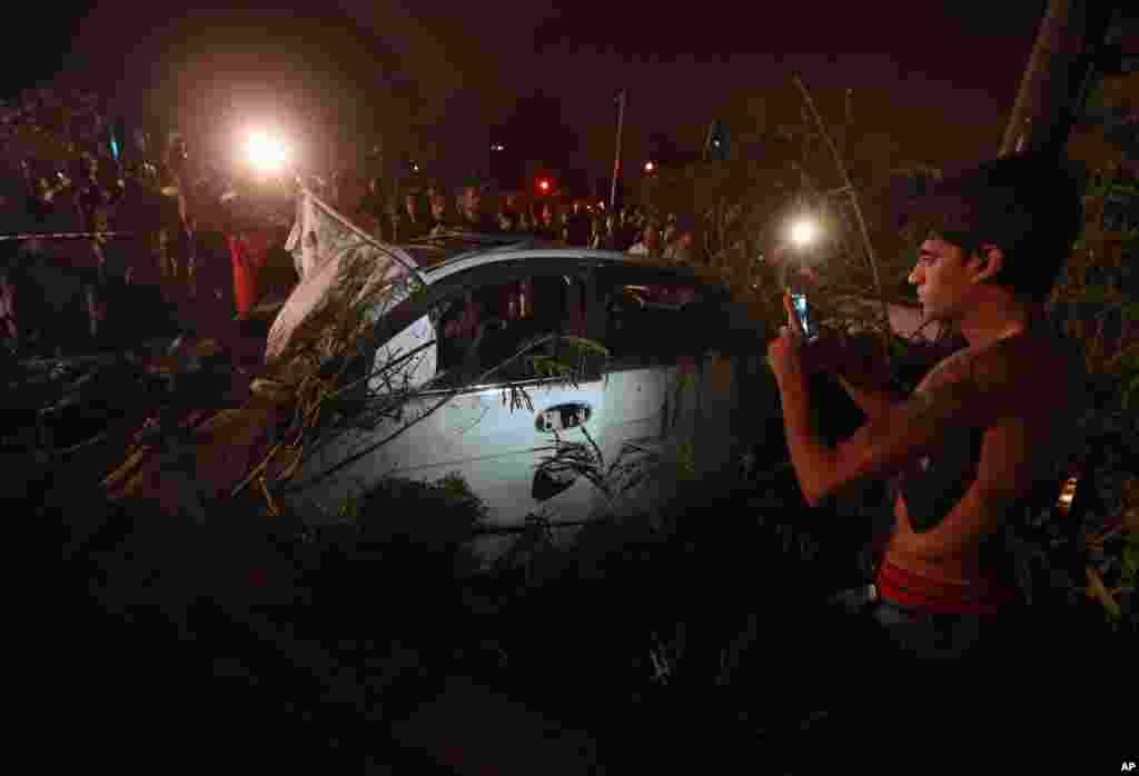 Lebanese soldiers and citizens gather at the site of a car bombing in a southern suburb of Beirut, June 24, 2014.