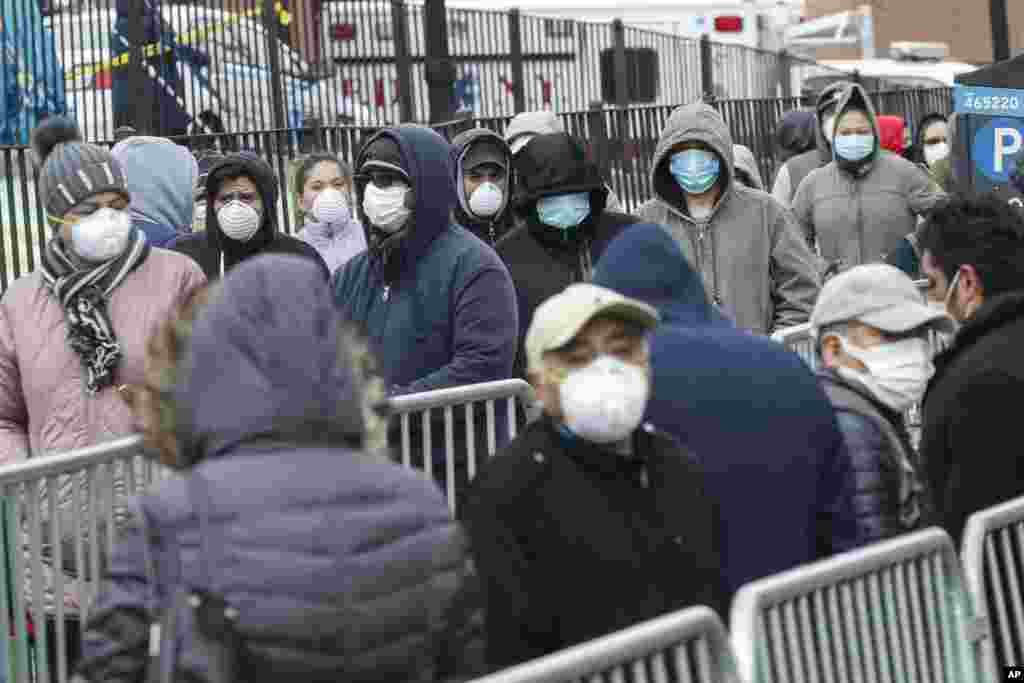 Patients wait in line for a COVID-19 test at Elmhurst Hospital Center, in New York City, March 25, 2020.