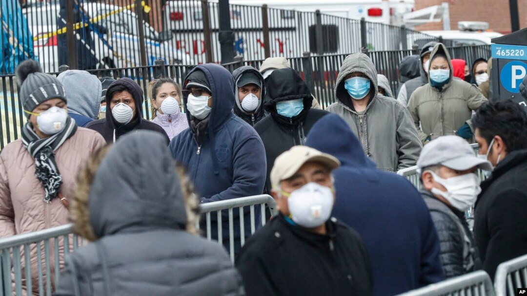 Patients wait in line for a COVID-19 test at Elmhurst Hospital Center, in New York City, March 25, 2020.