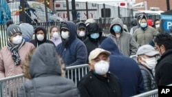 Patients wait in line for a COVID-19 test at Elmhurst Hospital Center, in New York City, March 25, 2020.