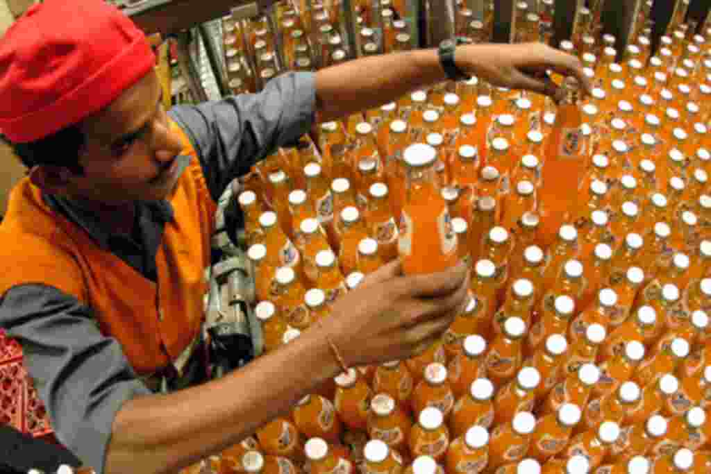 A Indian man with hearing and speech disability works at Hindustan Coc-Cola Beverages Comapny factory in Madras. Selvakumar, who suffers both hearing and speech disability, adjusts bottles inside a factory in the southern Indian city of Madras August 18,