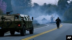 ARCHIVO - La policía lanza gases lacrimógenos para desalojar a indígenas mapuches de una tierra que ocupaban por años cerca de Villa Mascardi, Argentina, el 4 de octubre de 2022. 