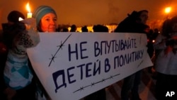 FILE - Russian child's death follows international controversy over the Russian ban on U.S. adoptions; protest sign says "Do not involve children in politics," St. Petersburg, Dec. 26, 2012.