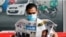A man wearing a face mask reads a newspaper with the front page headline reporting on Joe Biden's projected U.S. presidential election victory, in Manama, Bahrain, Nov. 8, 2020.