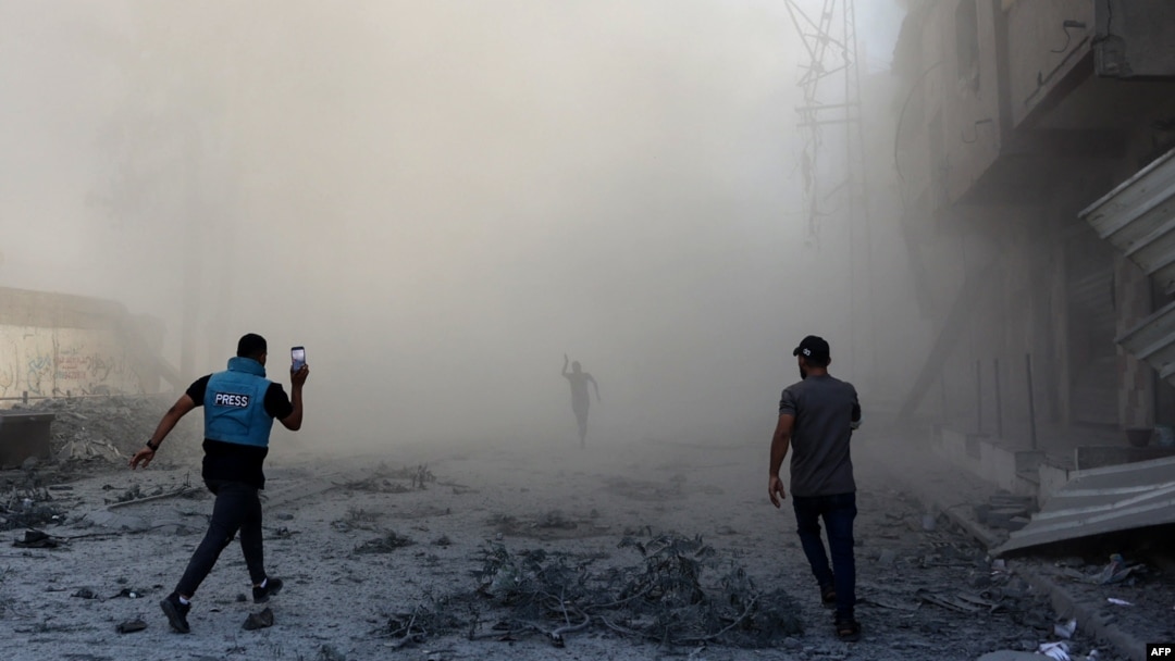 People and a journalist rush toward the scene of an explosion following an Israeli strike which reportedly targeted a school in the Zeitoun district on the outskirts of Gaza City, on Sept. 1, 2024.