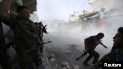 Free Syrian Army fighters run for cover after Syrian forces fired a mortar in the El Amreeyeh neighborhood of Syria's northwestern city of Aleppo August 30, 2012.