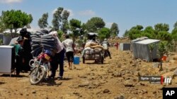 This July 5, 2018 photo provided by Nabaa Media, a Syrian opposition media outlet, shows people who fled from Daraa province, gathering in the Quneitra countryside, near the Israeli-occupied Golan Heights. 