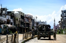 FILE - Soldiers are seen on truck among destroyed buildings in Marawi City, southern Philippines, May 23, 2019.