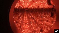 Colored lights appear in the Infinity Mirror Room created by Japanese artist Yayoi Kusama, part of the exhibit, "Yayoi Kusama: Festival of Life," on display at the David Zwirner gallery in the Chelsea section of New York, Nov. 21, 2017.