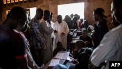 Les électeurs font la queue pour retirer leur carte au bureau de vote à l'école Koudoukou dans le quartier PK5, à Bangui, 14 décembre 2015