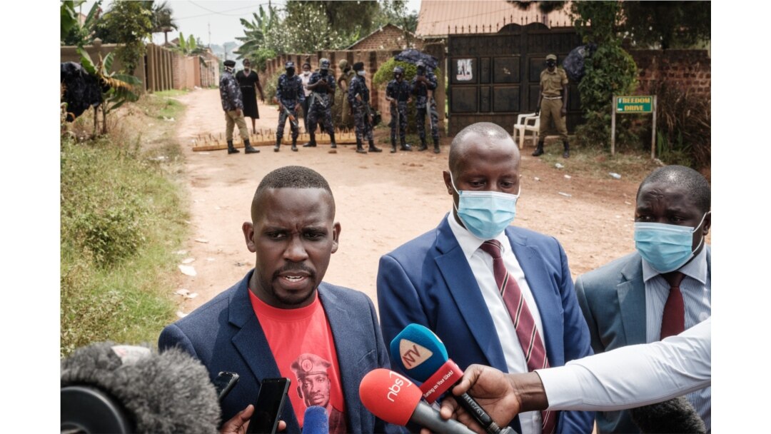 FILE - Joel Ssenyonyi, left, spokesperson of National Unity Platform, speaks to media with lawyers of Bobi Wine, after being blocked to enter at the security checkpoint near Kyaguolanyi's home in Magere, Uganda, Jan. 18, 2021.