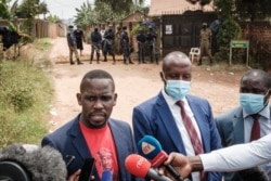 FILE - Joel Ssenyonyi, left, spokesperson of National Unity Platform, speaks to media with lawyers of Bobi Wine, after being blocked to enter at the security checkpoint near Kyaguolanyi's home in Magere, Uganda, Jan. 18, 2021.