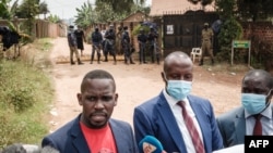 FILE —Joel Ssenyonyi, the spokesperson of Uganda's National Unity Platform speaks to media alongside legal representatives of Robert Kyagulanyi, aka Bobi Wine, after being blocked from entering a security checkpoint close to Wine's home, Jan. 18, 2021.