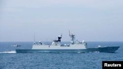 FILE - A Chinese naval helicopter prepares to land aboard the People's Liberation Army frigate CNS Huangshan in the South China Sea, June 16, 2017.