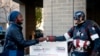 US -- Matt Gnojek, a.k.a. Colorado Captain, hands out stickers to a voter in Denver, Colorado on November 6, 2018.