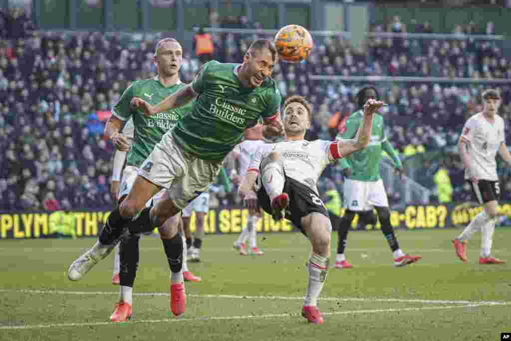 Plymouth Argyle&#39;s Nikola Katic, left, clears the ball next to Liverpool&#39;s Diogo Jota during the English FA Cup fourth round soccer match between Plymouth Argyle and Liverpool at Home Park stadium in Plymouth, England.