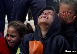 Children cry as people mourn Palestinians killed in an Israeli strike, at Nasser hospital in Khan Younis in the southern Gaza Strip, Dec. 5, 2024.