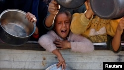 Palestinians in Khan Younis clamor for food from a charity kitchen during a hunger crisis in the southern Gaza Strip, Dec. 4, 2024.