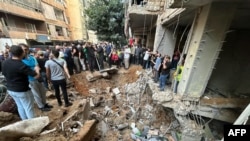 People check the damage at the scene of an Israeli strike in Beirut's southern suburbs on Sept. 20, 2024. 