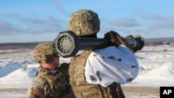 A U.S. instructor trains a Ukrainian soldier how to use a M141 Bunker Defeat Munition (SMAW-D) missile at the Yavoriv military training ground, near Lviv, western Ukraine, Jan. 30, 2022. (Ukrainian Defense Ministry Press Service via AP) 