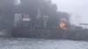 In this image taken from video provided by Denys Mezentsev, rescue crews work on site after a cargo ship was hit by a tanker carrying jet fuel for the U.S. military off eastern England, March 10, 2025, setting both vessels ablaze. (Denys Mezentsev via AP)