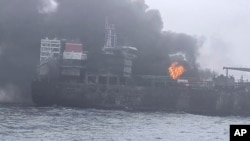 In this image taken from video provided by Denys Mezentsev, rescue crews work on site after a cargo ship was hit by a tanker carrying jet fuel for the U.S. military off eastern England, March 10, 2025, setting both vessels ablaze. (Denys Mezentsev via AP)