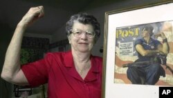 FILE - Mary Doyle Keefe poses at her home in Nashua, New Hampshire, with the May 29, 1943, cover of the "Saturday Evening Post" for which she had modeled as "Rosie the Riveter" in a Norman Rockwell painting, May 22, 2002.