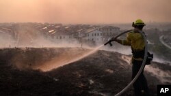 Un bombero combate las llamas del incendio que amenaza a la comunidad de Irvine, en el sur de California, el 26 de octubre de 2020.