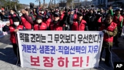 FILE - Dog farmers shout slogans during a rally against the government-led dog meat banning bill in Seoul, South Korea on Nov. 30, 2023. The banner reads 'Guarantee the right to life and freedom of choice of occupation.'