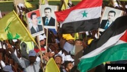 Supporters of Lebanon's Hezbollah leader Sayyed Hassan Nasrallah carry flags and pictures of Syria's President Bashar al-Assad during a rally marking al-Quds Day, Jerusalem Day, in Maroun Al-Ras village, near the border with Israel, southern Lebanon, June