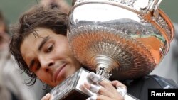 El tenista español Rafa Nadal sostiene su trofeo de campeón del Abierto de Francia, conquistado tras derrotar al serbio Novak Djokovic en la final de Roland Garros.