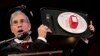Master of Ceremonies Marc Abrahams holds up the 2014 Ig Nobel Prize trophy during a performance at the Ig Nobel Prize ceremony at Harvard University, in Cambridge, Mass., Sept. 18, 2014. 