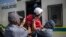 Des agents du Service de police sud-africain embarquent un étudiant membre des combattants de la liberté économique (EFF) à l'intérieur d'un fourgon de police lors d'une manifestation à Braamfontein, Johannesburg, le 10 mars 2021.